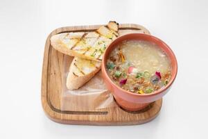 Chicken Corn Soup with garlic bread served in a bowl isolated on grey background top view photo