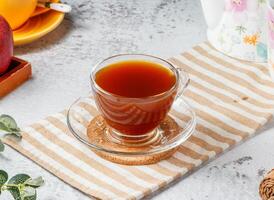 Black coffee in glass cup with coffee powder on mat with grey background photo