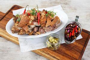 Chili Garlic Pork Knuckle Cripy Pata with spicy salad served in a dish isolated on grey background side view photo