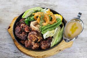 Sizzling Bone Marrow Bulalo and Truffled Mushroom Gravy served in a dish isolated on grey background side view of stewed photo