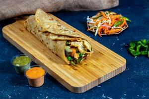 egg and Vegetable shawarma wrap with salad dip and sauce isolated wooden board side view of fastfood photo