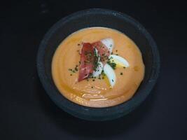 frío tomate sopa Español estilo servido en un plato aislado en oscuro antecedentes parte superior ver foto