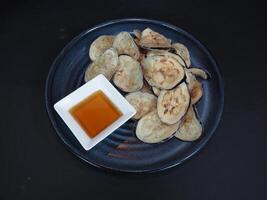 Eggplant Chips served in a dish isolated on dark background top view photo