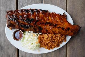 HOUSE CLASSIC RIBS AND CHICKEN Rice in a dish top view on grey background singapore food photo