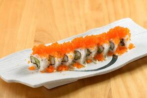 Japanese sushi food rainbow maki in a white tray isolated on wooden table top view photo