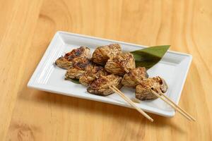 japonés comida frito shiitake con palos en un plato aislado en de madera antecedentes parte superior ver foto