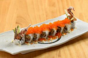 japonés comida delicioso araña maki rodar en un blanco plato aislado en de madera mesa parte superior ver foto