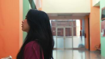 Silhouette of a woman walking in a corridor with soft natural lighting and a blurred background. video