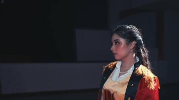 Side profile of a woman in historical costume with dramatic lighting on stage. video