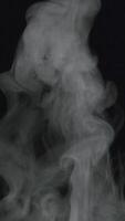 video vertical en cámara lenta de humo blanco, niebla, niebla, vapor sobre un fondo negro.