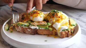 Close up of a dish with eggs, ham, and avocado on a toast video