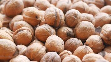 A scoop of walnuts, a superfood, rests on a stack of nuts seeds video