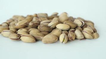 slow motion of pistachios nuts dropping on white background video