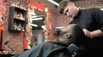 le coiffeur coupes avec les ciseaux et peignes le du client barbe avec une peigne. barbe se soucier video