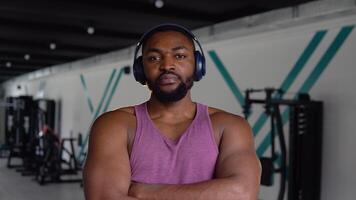 africain américain homme avec écouteurs à la recherche à le caméra dans le Gym video