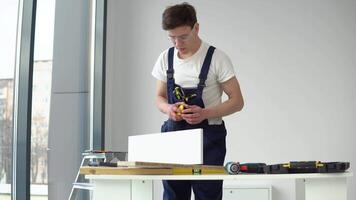 The carpenter in protective glasses measures the parts video