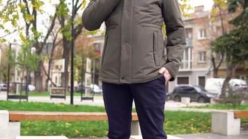 Nahansicht von ein Mann im ein Grün Jacke von das Neu Sammlung auf das Straße video
