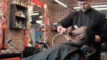 le coiffeur coupes avec les ciseaux et peignes le du client barbe avec une peigne. barbe se soucier video