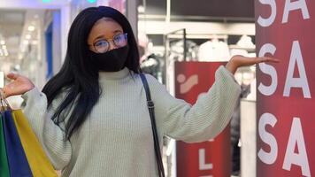 sorridente africano americano menina enquanto compras dentro a supermercado. grande venda video