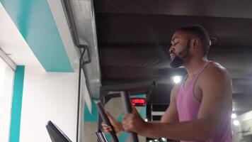 africain américain barbu homme faire des exercices sur elliptique entraîneur dans le Gym video