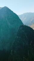 High mountain in the bright light and fog. Gorgeous beautiful rocks of Yosemite National Park, California, USA on hazy morning. Vertical video