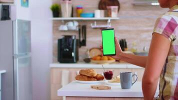 participación teléfono con verde toque pantalla en cocina y marido recoger arriba un caja de huevos desde refrigerador. verde pantalla croma burlarse de arriba aislado Bosquejo antecedentes Listo a ser sustituido con tu texto, logo o anuncio publicitario. utilizando Internet, social redes y hojeada video