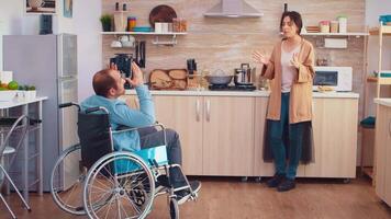 Wife screaming in kitchen to her disabled man in wheelchair while having a disagreement. Guy with paralysis handicap disability handicapped difficulties getting help for mobility from love and relationship video