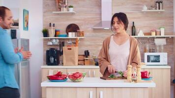 casado Pareja preparando ensalada con Fresco vegetales en cocina. Cocinando preparando sano orgánico comida contento juntos estilo de vida. alegre comida en familia con vegetales video