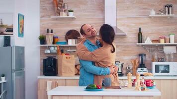 vrolijk paar glimlachen en dansen in keuken. romantisch man en vrouw. vrolijk gelukkig jong familie samen dans. pret liefde genegenheid romance vrije tijd romantisch muziek- voor genot video