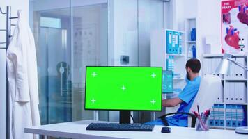 Arzt ankommen im Gesundheit Klinik mit Computer haben Chroma Schlüssel auf Anzeige. Desktop mit leer und Kopieren Raum verfügbar auf Anzeige von Medizin Spezialist im Klinik Kabinett. video