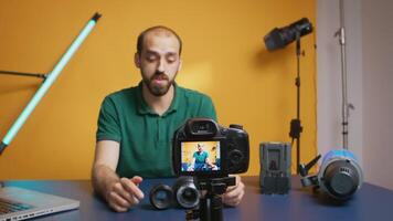 photographe parlant à propos lentille spécification tandis que enregistrement vlog épisode pour les abonnés. caméra lentille La technologie numérique enregistrement social médias influenceur contenu créateur, professionnel studio pour podcast, vlogging et bloguer video