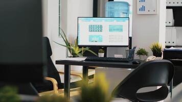 Computer screen on office desk showing volatile stock exchange prices going up and down. Brokerage firm with forex trading platforms indexes on desktop PC monitor, panning shot video