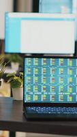 Vertical video Desk in empty office with laptop showing stock exchange data collected to develop trading strategies. Forex analytics on notebook screen in company workplace showing trading platform