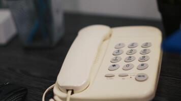 Close up shot of telephone on office desk and computer monitor showing stock exchange values going up and down. Phone on financial department workspace table and forex trading platform on monitor video