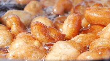 Traditional fried sweets lokma in sugar syrup in slow motion video