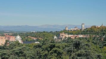 Madrid paesaggio urbano con lontano montagne, panoramico Visualizza di di madrid orizzonte con foresta primo piano e montagna sfondo. video