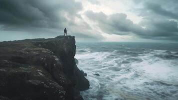 ai generado Resiliencia y esperanza figura soportes en azotado por el viento acantilado frente a turbulento Oceano abrazado por claro tormenta y iluminado por el sol cielo foto