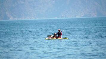 Woman Sup Sea. two woman learns to paddle sup board in open sea ocean on hot sunny day. Summer holiday vacation and travel concept. Aerial view. Slow motion video