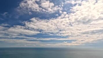 Timelapse fluffy Cumulus clouds moving in blue summer sky over calm sea. Abstract aerial nature summer ocean sunset, sea and sky view. Vacation, travel, holiday concept. Weather and Climate Change video