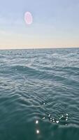 Sea water surface. Low angle view from kayak, camera flies over clear calm sea water. Nobody. Holiday recreation concept. Abstract nautical summer ocean nature. Slow motion. Close up. Vertical video