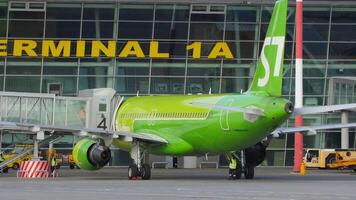 Kazan, russo federazione, agosto 5, 2022. Jet aereo airbus a320 di s7 le compagnie aeree vicino passeggeri terminale 1a di kazan internazionale aeroporto. aereo a il telescopico passerella, grembiule video