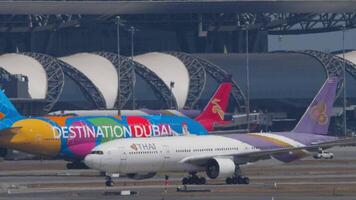 BANGKOK, THAILAND - JANUARY 20, 2023. Boeing 777 of THAI at Suvarnabhumi Airport, Bangkok. Huge double-decker Airbus A380 Emirates taxiing to the terminal video