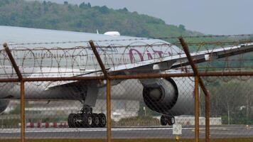 PHUKET, THAILAND - JANUARY 31, 2023. Boeing 777, A7-BAP of Qatar Airlines taking off, departing at Phuket airport. Tourism and travel concept. The plane picks up speed video