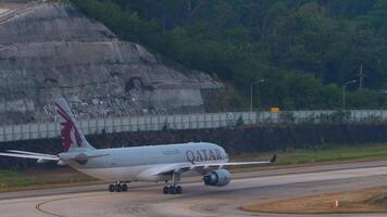 phuket, Thailand - februari 23, 2023. schot van luchtbus a330, a7-aci van qatar luchtwegen taxiën Bij phuket luchthaven. beeldmateriaal van passagier vliegtuig Aan de taxi weg, vliegveld video