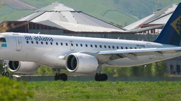 Almaty, Kasachstan - - kann 5, 2019. Seite Sicht, Passagier Flugzeug Umarmung e190, p4-khb von Luft Astana berühren das Runway beim Almatie Flughafen. Flug Bremsung nach Landung. Spoiler oben video