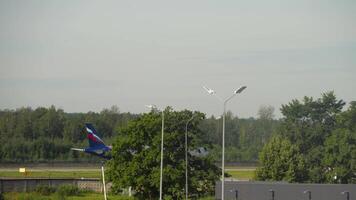 SAINT PETERSBURG, RUSSIA - JULY 26, 2022. Aeroflot passenger plane arriving, braking at Pulkovo airport, side view. Aircraft landing. Airplane slowing down video