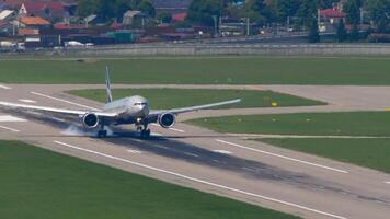 SOCHI, RUSSIA - JULY 30, 2022. Widebody Boeing 777 of Aeroflot landing at Sochi airport at night. Front view, jet passenger plane touching the runway and slow down, braking video