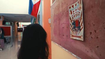 Rear view of a person walking down a colorful hallway with artwork on the walls. video