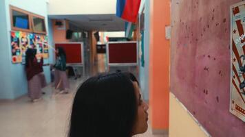 Rear view of a person walking down a colorful hallway with artwork on the walls. video