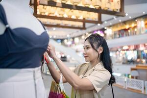 young woman in smart casual wear carrying many paper shopping bags walking and shopping in clothing and shoe at shopping center photo